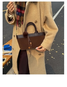 Dettaglio borsa tote in pelle scamosciata marrone con pompon e nappa in perline di legno