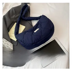 Detail of navy blue quilted shoulder bag featuring heart-shaped stitching pattern