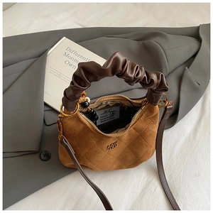 Brown quilted dumpling bag in suede finish with pleated handle and slim crossbody strap