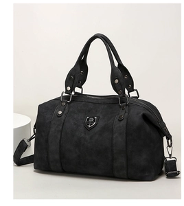 Detailed shot of black matte texture tote with metal logo and adjustable strap