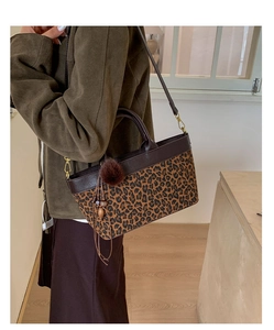 Dettaglio della borsa tote leopardata con manici in pelle marrone e nappa decorativa