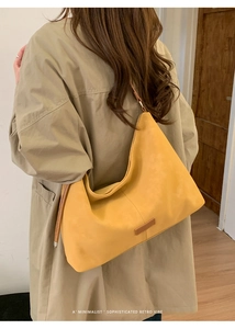 Gros plan du grand sac hobo jaune mat avec accents en cuir marron et fine bandoulière