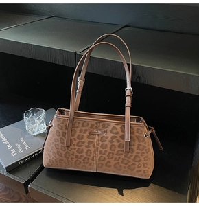 Close-up of the leopard print suede fabric texture and gold brand logo on the bag