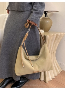 Détail du sac hobo beige minimaliste avec poignée enroulée unique et texture mate rétro