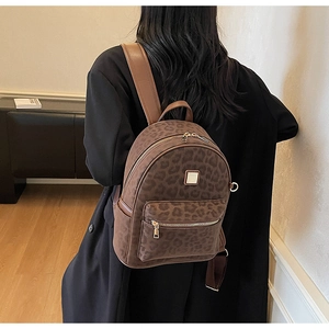 Vue arrière du mannequin portant un sac à dos vintage léopard avec bordure en cuir