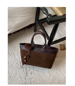 Dettaglio della borsa tote in pelle scamosciata marrone scuro con nappe decorative