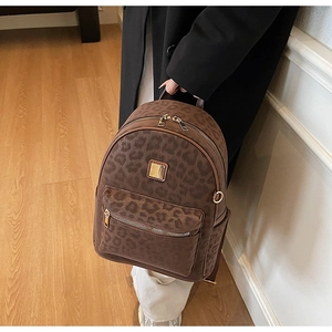 Détail du sac à dos vintage imprimé léopard avec poche zippée et plaque de logo dorée