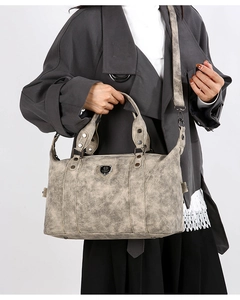 Macro shot of retro tote bag showing frosted texture, metal logo and vintage bronze hardware