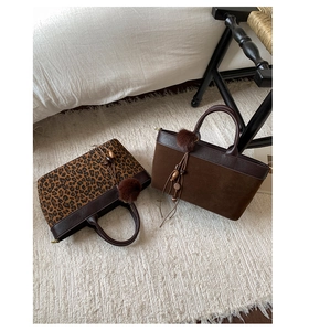 Dettaglio della borsa tote leopardata con nappe bohémien e ciondolo in perline di legno