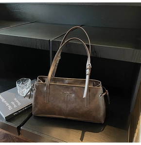 Macro shot of dark brown matte leather handbag with drawstring detail and metal logo