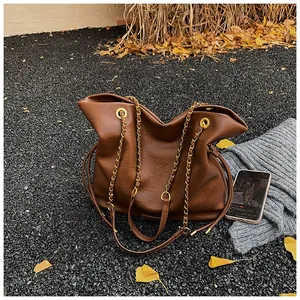 Brown faux leather tote bag detail with metal chain strap and autumn aesthetic elements