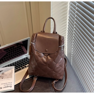 Detailed view of brown quilted PU leather backpack with sleek silver metal zippers