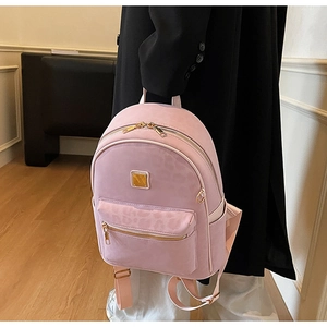 Détail d'un mini sac à dos rose clair avec poche léopard et plaque logo dorée
