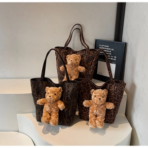 Dettaglio di borse tote leopardate e cachemire con ciondoli a forma di orsetto di peluche
