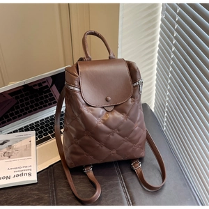 Brown leather backpack featuring diamond stitching and floral embossing in a lifestyle setting