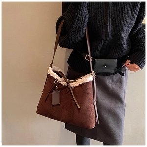 Detail of coffee suede underarm bag with white faux fur trim and leather bow decoration