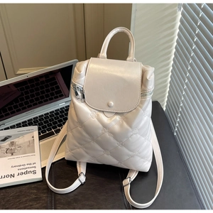 Detail of cream quilted backpack with floral embroidery and gold side zipper detail