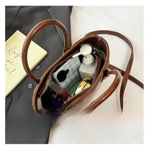 Vue de dessus de l'intérieur du sac seau en cuir marron foncé et compartiments