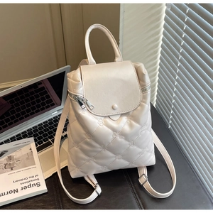 Close-up of quilted floral embroidery and metal zipper on beige leather backpack