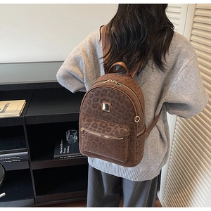 Détail d'un sac à dos vintage à imprimé léopard avec des finitions dorées