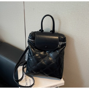 Detail of black quilted leather backpack with diamond lattice pattern and metallic zipper