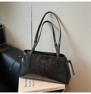 Detail of vintage black tote bag with textured faux leather and adjustable straps