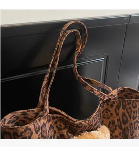 Dettaglio della borsa tote leopardata con texture scamosciata e robuste tracolle