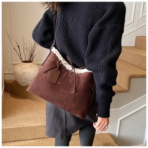 Detailed shot of brown faux suede shoulder bag with plush white faux fur trim detail