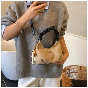 Detail of camel suede dumplings bag with quilted texture and scrunchie handle