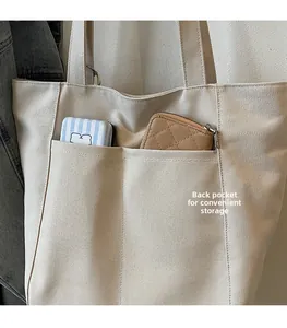 Detail of canvas tote bag with front pockets for card storage and reinforced stitching