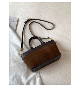 Dettaglio della borsa tote marrone con texture in pelle liscia e scamosciata