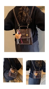 Detail of dark brown vintage backpack with contrast stitching and metal snap closure