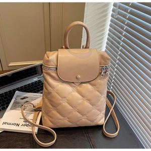 Detail view of beige quilted backpack texture and micro floral embossing on faux leather
