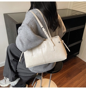 Close-up of cream white tote bag with adjustable shoulder strap and leather texture