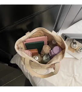 Spacious interior of beige canvas tote showing storage for tablet and essentials