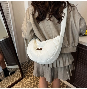 Detailed back view of white crescent cloud bag with heart quilting and wide shoulder strap