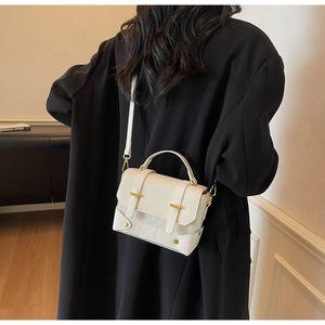 Détail du petit sac blanc en cuir avec boucle en métal et longue bandoulière réglable