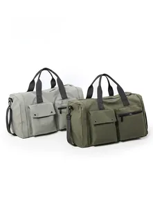 Detail of grey and green travel bags featuring front pockets and detachable straps