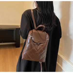Brown quilted faux leather backpack for women shown from behind on a fashion model