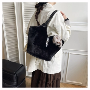 Detail of black faux fur shoulder bag featuring silver clasp and cute rabbit charm