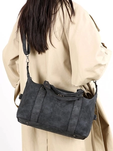 Retro washed black tote bag with dual handles and adjustable strap worn by model