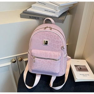 Détail du sac à dos léopard rose avec fermeture éclair dorée et texture sur la poche