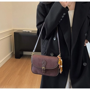 Close-up of a vintage dark brown frosted shoulder bag featuring stylish wood bead tassels