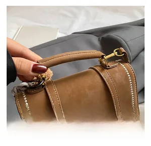 Close-up of brown vintage leather bag featuring contrast stitching and gold hardware details