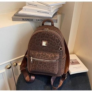 Détail du sac à dos vintage à imprimé léopard avec poignée en cuir marron et boucle en métal