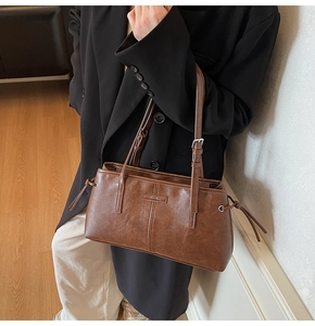 Brown vintage style tote bag with adjustable shoulder strap and tassel drawstring detail