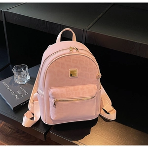 Détail d'un mini sac à dos rose avec motif léopard embossé et finitions en métal doré