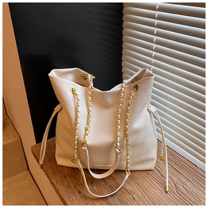 Detail of cream white leather bucket bag with gold chain strap and side drawstrings