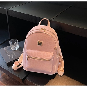 Détail du sac à dos rose à motif léopard avec quincaillerie dorée et poche avant