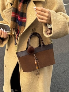 Borsa a tracolla vintage in camoscio marrone con nappa pompon indossata dalla modella